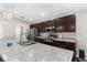 Open concept kitchen with stainless steel appliances, dark wood cabinets, and a central island with granite countertop at 11940 Stone Pine St, Riverview, FL 33569