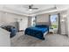 Large main bedroom offers a tray ceiling, ceiling fan, neutral walls, carpet flooring, and natural light at 11940 Stone Pine St, Riverview, FL 33569