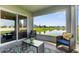 Relaxing covered patio overlooking a serene pond with seating and decorative rug at 11940 Stone Pine St, Riverview, FL 33569