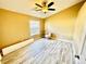 Bright bedroom with light hardwood floors, a ceiling fan and a white door at 12249 Country White Cir, Tampa, FL 33635
