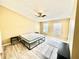 Bright bedroom with a ceiling fan, light hardwood floors and two windows at 12249 Country White Cir, Tampa, FL 33635