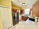 Kitchen with a stainless steel fridge, light-colored countertops, and wood cabinets at 12249 Country White Cir, Tampa, FL 33635