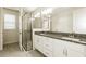Modern bathroom featuring double vanities, granite countertops, and a glass-enclosed shower at 13408 Nimble Minke # 155E, Riverview, FL 33579