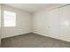 A simple bedroom includes a window, closet, and comfortable gray carpeting at 13408 Nimble Minke # 155E, Riverview, FL 33579