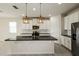 Modern kitchen featuring white cabinets, stainless steel appliances, a large island, and pendant lighting at 13408 Nimble Minke # 155E, Riverview, FL 33579