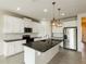 Modern kitchen featuring white cabinets, stainless steel appliances, a large island, and pendant lighting at 13408 Nimble Minke # 155E, Riverview, FL 33579