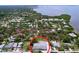Aerial view of the property within a tranquil, tree-filled neighborhood and a glimpse of the waterfront nearby at 1445 Coburn Dr, Tarpon Springs, FL 34689