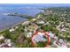 Aerial view showcasing the property's location near the water and surrounded by lush greenery and other residences at 1445 Coburn Dr, Tarpon Springs, FL 34689