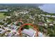 Aerial shot displays a property nestled in a verdant neighborhood, complemented by a community swimming pool at 1445 Coburn Dr, Tarpon Springs, FL 34689