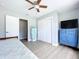 Bright bedroom with ceiling fan, closet and decorative cabinet at 1445 Coburn Dr, Tarpon Springs, FL 34689