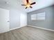 This bedroom features wood-look floors, fresh paint, a ceiling fan, and a sliding-door closet at 1445 Coburn Dr, Tarpon Springs, FL 34689