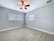 This bedroom features wood-look floors, fresh paint, a ceiling fan, and two windows at 1445 Coburn Dr, Tarpon Springs, FL 34689
