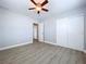 This bedroom features wood-look floors, fresh paint, and a sliding-door closet at 1445 Coburn Dr, Tarpon Springs, FL 34689