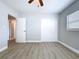 This bedroom features wood-look floors, fresh paint, and a sliding-door closet at 1445 Coburn Dr, Tarpon Springs, FL 34689
