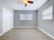 This bedroom features wood-look floors, fresh paint, a ceiling fan, and a sliding-door closet at 1445 Coburn Dr, Tarpon Springs, FL 34689