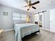 Cozy bedroom with a ceiling fan and a sliding door to an ensuite bathroom at 1445 Coburn Dr, Tarpon Springs, FL 34689