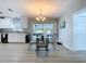 Dining room with white kitchen in background, decorative table and chandelier, and view to outside at 1445 Coburn Dr, Tarpon Springs, FL 34689