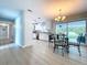 Bright dining area with white kitchen in background, showcasing open floor plan and modern finishes at 1445 Coburn Dr, Tarpon Springs, FL 34689