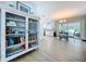 View of dining room with decorative cabinet and view of white kitchen and a covered outdoor area at 1445 Coburn Dr, Tarpon Springs, FL 34689