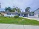 Charming home with manicured lawn, palm trees, dark shutters, and a welcoming entrance at 1445 Coburn Dr, Tarpon Springs, FL 34689