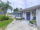 Charming single-story home featuring a well-manicured lawn and an inviting blue front door at 1445 Coburn Dr, Tarpon Springs, FL 34689