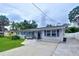 Inviting single-story home with a lush green lawn, neat landscaping, and a spacious driveway at 1445 Coburn Dr, Tarpon Springs, FL 34689