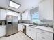 Well-lit kitchen featuring stainless steel appliances, white cabinets, and modern fixtures at 1445 Coburn Dr, Tarpon Springs, FL 34689