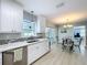 Bright kitchen featuring white cabinetry, stainless steel appliances, and quartz countertops, open to a dining area at 1445 Coburn Dr, Tarpon Springs, FL 34689