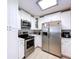 Bright kitchen showcasing stainless steel appliances, white cabinetry, and quartz countertops at 1445 Coburn Dr, Tarpon Springs, FL 34689