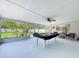 Bright enclosed patio with a pool table, fan, decor and furniture, offering a pleasant relaxation space at 1445 Coburn Dr, Tarpon Springs, FL 34689