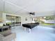 Enclosed patio featuring a pool table, sliding glass doors and views of an outdoor space with green landscape at 1445 Coburn Dr, Tarpon Springs, FL 34689