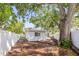 Spacious backyard with a large tree and a white fence at 1518 Cheyenne Ne St, St Petersburg, FL 33703