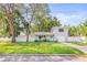 Charming two-story home featuring a manicured lawn, a white fence and a single car garage at 1518 Cheyenne Ne St, St Petersburg, FL 33703