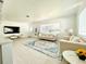 Bright living room featuring neutral furniture, large windows, and stylish rug on light wood floors at 1518 Cheyenne Ne St, St Petersburg, FL 33703