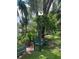 Landscaped backyard with a charming green bench, lush gardens, and mature trees, creating a peaceful retreat at 15316 Winding Creek Dr, Tampa, FL 33613