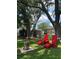 Relaxing backyard with Adirondack chairs, modern fire pit, and beautiful landscaping under mature trees at 15316 Winding Creek Dr, Tampa, FL 33613
