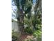 Lush backyard featuring mature trees, flower beds, and a white privacy fence at 15316 Winding Creek Dr, Tampa, FL 33613