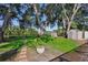 Expansive backyard with lush greenery, mature trees, storage shed, swing and scenic lake view at 15316 Winding Creek Dr, Tampa, FL 33613