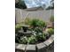Backyard garden space with fountain, flowers and a white fence at 15316 Winding Creek Dr, Tampa, FL 33613