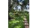 Backyard with a cozy wooden porch swing, lush green lawn, and mature trees, perfect for outdoor relaxation at 15316 Winding Creek Dr, Tampa, FL 33613