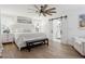 Bright bedroom features a ceiling fan, wood floors, and sliding barn door to bath at 15316 Winding Creek Dr, Tampa, FL 33613