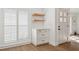 Entryway featuring white cabinets, floating shelves, shutters, and a light wood floor at 15316 Winding Creek Dr, Tampa, FL 33613