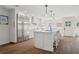 Modern kitchen with island, stainless steel refrigerator, white cabinets, and wood floors at 15316 Winding Creek Dr, Tampa, FL 33613