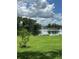 Scenic lake view from the property, showcasing a tranquil waterfront with lush greenery and a clear blue sky at 15316 Winding Creek Dr, Tampa, FL 33613