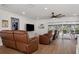 Inviting living room with hardwood floors, leather recliners, and screened windows overlooking the lanai at 15316 Winding Creek Dr, Tampa, FL 33613