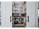 Well-organized pantry with white shelving and sliding barn doors at 15316 Winding Creek Dr, Tampa, FL 33613
