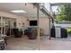 Inviting covered patio featuring a comfortable seating area with a mounted television and outdoor grill at 15316 Winding Creek Dr, Tampa, FL 33613