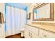 Bathroom with granite countertops, white cabinets, and blue tile accents at 1592 Cumberland E Ct, Palm Harbor, FL 34683