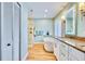 Bright bathroom with a soaking tub, a walk-in shower, and a modern vanity with an illuminated mirror at 1592 Cumberland E Ct, Palm Harbor, FL 34683