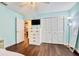 Bedroom with wood floors, closet, and light blue walls with white trim at 1592 Cumberland E Ct, Palm Harbor, FL 34683